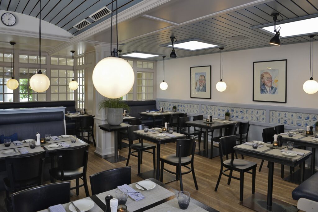 Ambiente des BOCK's im Parkhotel Kronsberg, gedeckte Tische in beleuchtettem Raum, grau/ schwarzes Farbspiel