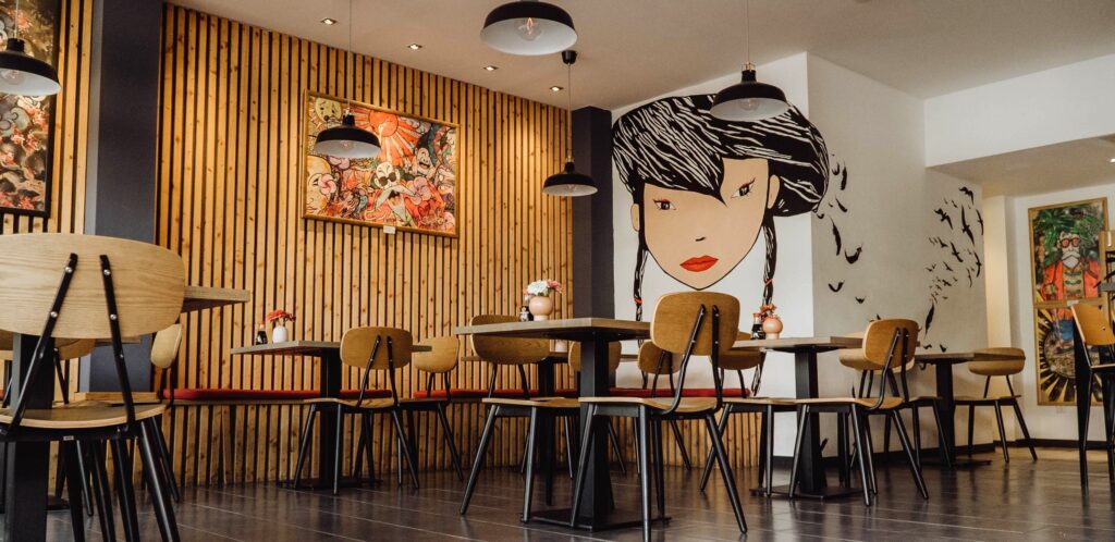 Innenraum der Kazumi Sushi Manufaktur, Tische mit Stühlen, asiatisches Ambiente