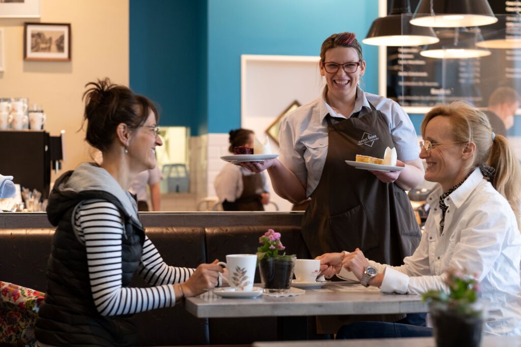 anna leine, zwei Frauen sitzen im Café und werden bedient