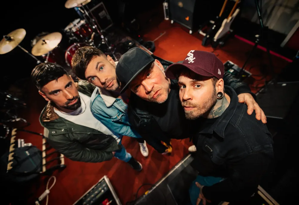 四名乐队成员在舞台上摆出乐器和技术的造型，鸟瞰镜头。